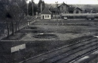 Widok z okna biurowca na portiernię i dworzec PKP.
